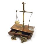 A set of Asco oak and brass Avery table scales, a single drawer to base enclosing various brass weig
