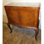 A mid 20thC walnut and burr walnut cocktail cabinet, the top with a glass insert above two crossband