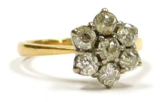 A diamond flower head ring, set with seven rose cut diamonds, set in white and yellow metal, stamped
