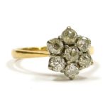 A diamond flower head ring, set with seven rose cut diamonds, set in white and yellow metal, stamped