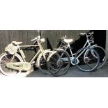 A Raleigh Caprice bicycle, in white trim, and a Raleigh Dynoluxe bicycle in green trim with a Brooks