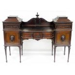 An Edwardian Adam style breakfront mahogany sideboard, the raised back with a central finial flame c