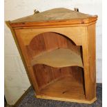 A pine hanging corner cabinet, with a moulded cornice above a single shaped open shelf, 70cm high, 5