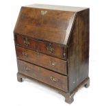 A George III oak bureau, the fall enclosing a fitted interior of five recesses over nine drawers, ab