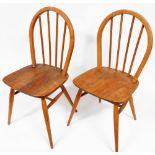 A pair of mid century Ercol type stick back Windsor chairs, each with a solid elm seat on turned leg