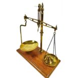 A set of late 19th/early 20thC brass table scales, the arms supporting two hanging pans, with a set
