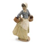 A Nao matte porcelain figure of a young girl holding baskets, printed and impressed marks, 36cm high