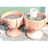 A pair of plastic urn planters, each with Greek key border and berry pattern, 55cm high, 58cm diamet