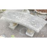 A reconstituted stone garden bench, the curved top on squirrel supports, 44cm high, 94cm wide, 37cm