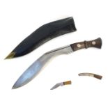 A curved Kukri dagger, marked TD with military arrows and two miniature blades, in a leather scabbar