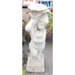 A reconstituted stone stand, formed as a boy carrying flower, 82cm high.