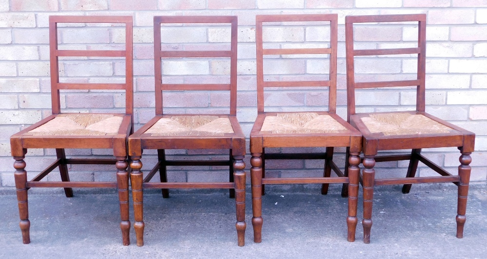 A set of four late 19th/early 20thC mahogany ladder back dining chairs, each with a rush seat on tur