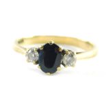 A 9ct gold dress ring, set with two CZ and a central dark blue imitation sapphire, ring size O, 2.2g