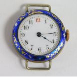An early 20thC silver and enamel watch head, raised with gilt coloured flowers and marked silver, wi