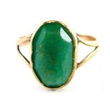 A 9ct gold polished jade dress ring, the oval jade in a rubover setting with V splayed shoulders, ri