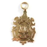 A Victorian 9ct gold fob, with scroll outline, centred by a shield, marked verso C & D J L 1898 Winn