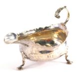 A George II silver sauce boat by James Crawford, with flying scroll handle, flared rim and triple ho