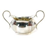 A George V silver Art Nouveau style two handled sugar bowl, with flared rim, bomb body and oval foot