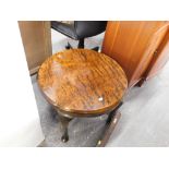 A circular coffee table, with a heavily polished top in exotic hardwood.
