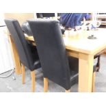 A lightwood dining room table and two leatherette chairs