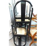 A set of four late 20thC ebonised dining chairs, each with a rattan seat.