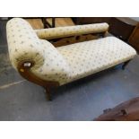 An early 20thC oak framed chaise lounge.