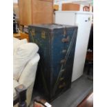 A large metal bound travel trunk, set with various labels, initialled BG and coloured with yellow an