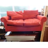 A three seater sofa bed settee in red material.