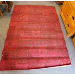 A machine woven red ground rug, 232cm x 166cm.