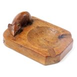 A Robert Thompson Mouseman oak ashtray, of rectangular shaped form with carved mouse, 10cm wide.