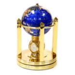 A gem stone globe clock, set with various semi precious stones, on a rotating base with quartz clock