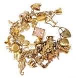 Withdrawn pre sale - A 9ct gold charm bracelet, with thirty one charms as fitted, on a heart shaped