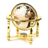 A gem stone terrestrial globe, inset with various semi precious stones, with a central compass benea