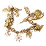 A 9ct gold fancy link charm bracelet, with sixteen charms as fitted, on a bolt ring clasp, 33.3g all
