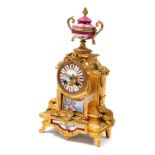 A late 19thC French porcelain and ormolu mantel clock, the circular dial bearing Roman numerals, eig