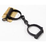 A pair of Victorian cast iron handcuffs, with a tag bearing hand written provenance.