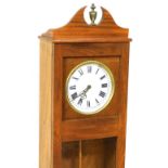 An electric wall clock, the dial with painted Roman numerals, in a teak case, the glazed door enclos