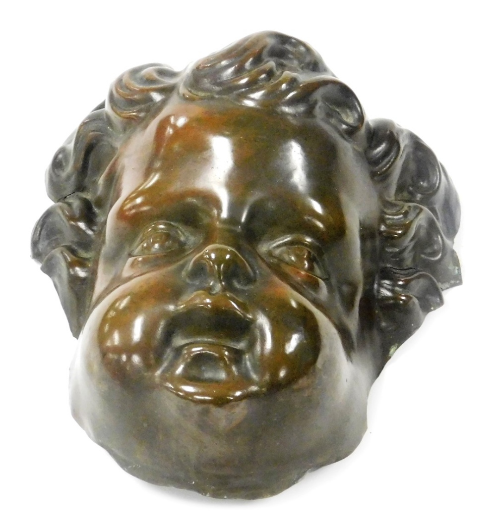 A 19thC bronzed tin metal mask of a cherub's head, 20cm high.