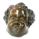 A 19thC bronzed tin metal mask of a cherub's head, 20cm high.