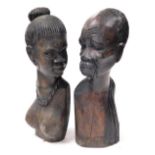 A pair of African tribal hardwood busts, carved as a lady wearing a necklace and earrings, and a gen