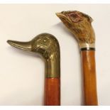 Two walking sticks, comprising a brass duck handled stick and a resin pheasant mounted stick, 93cm l