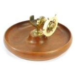A 20thC teak nut bowl, with brass and white plastic ship's wheel nutcracker, 23cm diameter.