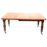 A Victorian mahogany extending dining table, with two loose leaves on reeded turned legs and casters
