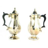 A pair of Edward & Sons from Glasgow EPNS chocolate pots, each with an ebonised and reeded side hand