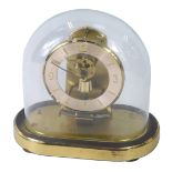 A Kundo Anniversary clock, with a brass numeric clock face, an open work movement with domed top, on