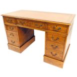A burr elm pedestal desk, the top with a brown leather inset top, above nine drawers, on a plinth, 8