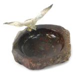 A mid century serpentine ashtray, with applied cold painted metal seagull to rim, 12cm diameter.