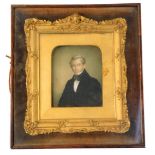 A 19thC portrait miniature of a gentleman in evening jacket, oil on stone table, in gilt frame, in a