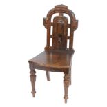 A 19thC oak hall chair, with a carved top and moulded back, on reeded tapering legs, 96cm high, 44cm