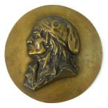 A brass wall plaque, with raised relief central figure of a gentleman in cap, 22.5cm diameter.